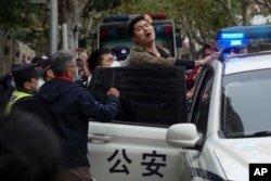 Polisi melakukan penangkapan terhadap pengunjuk rasa dalam aksi protes kebijakan lockdown COVID di Shanghai.