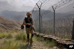 Pasukan Angkatan Darat Pakistan berpatroli di sepanjang pagar di perbatasan Pakistan Afghanistan di pos puncak Bukit Big Ben di Distrik Khyber, Pakistan. (Foto: AP)