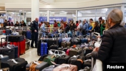 Southwest Airlines travelers wait in line to check on their baggage from their canceled flights at Chicago's Midway International Airport, Dec. 27, 2022.