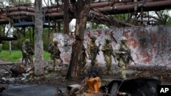 ARCHIVES - Des troupes russes à Marioupol, un territoire sous le gouvernement de la République populaire de Donetsk, dans l'est de l'Ukraine, le 18 mai 2022.
