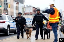 Petugas dengan anjing pelacak bom memeriksa area setelah terjadi penembakan di kereta bawah tanah pada Selasa, April. 12, 2022, di wilayah Brooklyn di New York. (Foto: AP)