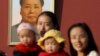 FILE - Two women and their babies pose for photographs in front of the giant portrait of late Chinese chairman Mao Zedong on the Tiananmen Gate in Beijing Nov. 2, 2015.