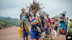 FILE - Residents flee fighting between M23 rebels and Congolese forces near Kibumba in the Democratic Republic of Congo, Oct. 29, 2022. 