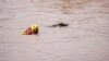 A search and rescue team member looks for bodies with the help of a dog, following torrential rains that triggered floods and mudslides, in Umbumbulu, near Durban, South Africa, April 18, 2022.