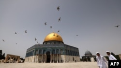 FILE - Palestinian Muslims walk in front of the Dome of Rock mosque at the Al-Aqsa mosque compound in Jerusalem's Old City, Apr. 17, 2022.