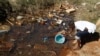 FILE - Residents fetch water from unprotected sources in Harare, Zimbabwe, July 28, 2012. The country is now dealing with another outbreak of typhoid fever.