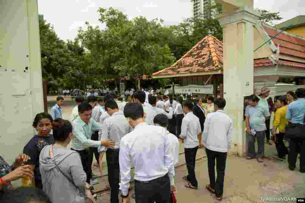បេក្ខជន​ប្រឡង​ឈរ​តំរង់​ជួរ​មុខ​មណ្ឌល​ប្រឡង​ដើម្បី​ធ្វើ​ការ​ឆែក​រក​សំណើរ​ឯកសារ​មុន​ចូល​មណ្ឌល​ប្រឡង។ នៅ​រាជធានី​ភ្នំពេញ​ ថ្ងៃ​ចន្ទ ទី​២០ ខែ​សីហា ឆ្នាំ​២០១៨។ (ទី អូលីស្សា/VOA)