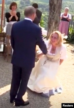 Austria's Foreign Minister Karin Kneissl dances with Russia's President Vladimir Putin at her wedding in Gamlitz, Austria, Aug. 18, 2018, in this picture grab taken from video. Kneissl's critics saw her curtsy to Putin as a sign of submission.