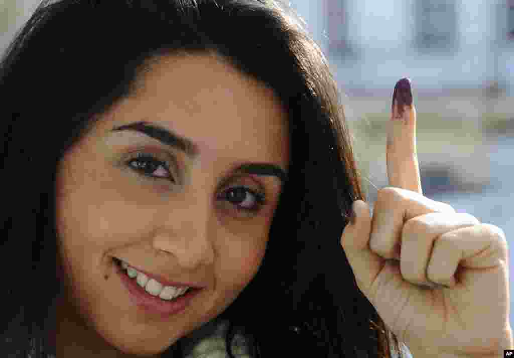 Une électrice tunisienne, Dina Ghlisse, 19 ans, présente&nbsp;son doigt avec la marque d&#39;encre indélébile après avoir voté à La Marsa, dans la banlieue de Tunis, Tunisie, dimanche 21 décembre 2014.