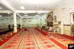FILE - In this photo released by the Saudi Press Agency SPA, Saudi officials and investigators, background, check a mosque inside a police compound after a suicide bombing attack in of Abha, the provincial capital of Asir, Saudi Arabia, Aug. 6, 2015.