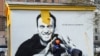 Un ouvrier peint sur un graffiti d'Alexei Navalny, critique du Kremlin, à Saint-Pétersbourg, le 28 avril 2021. L'inscription se lit comme suit : "Le héros des temps nouveaux".