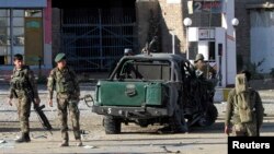 Afghan National Army (ANA) soldiers stand at the site of a blast in Jalalabad city, November 10, 2014.