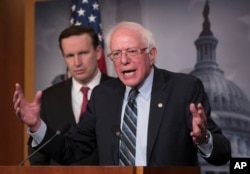 Sen. Bernie Sanders, I-Vt., joined at left by Sen. Chris Murphy, D-Conn., holds a news conference after the Senate passed a resolution he introduced that would pull assistance from the Saudi-led war in Yemen, a measure to rebuke Saudi Arabia after the killing of journalist Jamal Khashoggi, at the Capitol in Washington, Dec. 13, 2018.