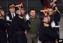 Presiden Ukraina Volodymyr Zelenskyy, tengah, dan Menteri Pertahanan Prancis Sebastien Lecornu, kanan, berjalan di landasan bandara Orly, Prancis, 8 Februari 2023. (Foto: via AP)
