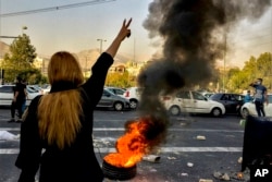 FILE - In this photo taken by an individual not employed by The Associated Press and obtained by the AP outside Iran, Iranians, including women, protest the death of Mahsa Amini, 22, after she was detained by the morality police, in Tehran, Iran, Oct. 1, 2022. For their bravery, Iran's female protesters were named the first recipients of the Madeleine Albright Honorary Group Award during the International Women of Courage award ceremony at the White House in Washington on International Women's Day, March 8, 2023.