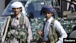 FILE - Houthi fighters stand outside a state security court in Sanaa, Yemen, Feb. 22, 2015.