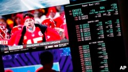 A person gambles as betting odds for NFL football's Super Bowl are displayed on monitors at the Circa resort and casino sports book, in Las Vegas, Feb. 3, 2023.