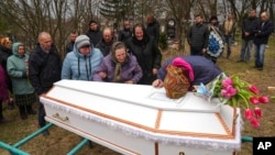People mourn April 8, 2022, in Chernihiv region, Ukraine, at the funeral of Veronika Kuts, 12, who was killed during a Russian bombardment in Ukraine.