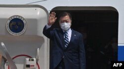 South Korean President Moon Jae-in waves from the steps of his plane as he leaves for the United States at Seoul Air Base in Seongnam, south of Seoul, on May 19, 2021. 