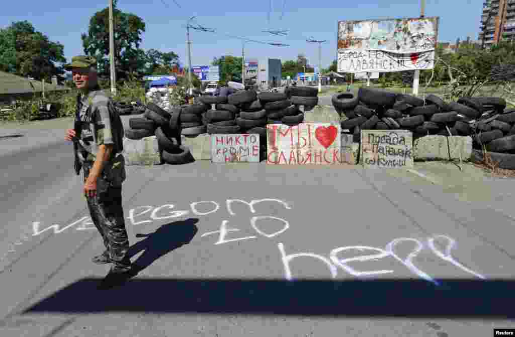An armed pro-Russian separatist stands guard at a check point in the Ukrainian eastern city of Slovyansk, July 1, 2014. 