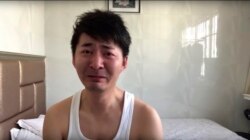In this image from video taken Feb. 4, 2020 and released by Chen Qiushi, Chinese citizen journalist Chen Qiushi speaks in front of a convention center-turned makeshift hospital amid a viral epidemic in Wuhan in central China's Hubei province. (Courtesy of