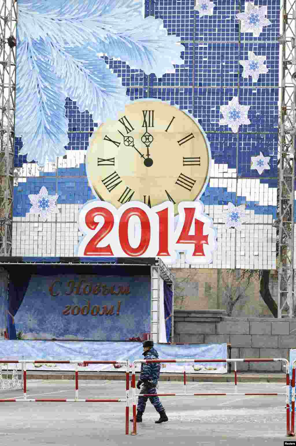 A policeman patrols a street with New Year's decorations, central Volgograd, Russia, Jan. 1, 2014.