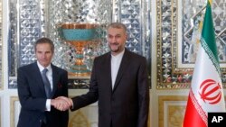 International Atomic Energy Organization, IAEA, Director General Rafael Mariano Grossi, left, and Iran's Foreign Minister Hossein Amirabdollahian shake hands prior to their meeting in Tehran, March 5, 2022.