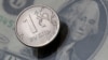 FILE - A view shows a Russian rouble coin and a U.S. dollar banknote in this picture illustration taken October 26, 2018.