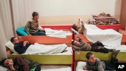 Interno raseljena djeca iz Mariupolja se spremaju za spavanje u obdaništu u Zaporožji