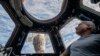 Astronaut AS Mark Vande Hei tampak melihat bumi dari jendela pada kubah dari Stasiun Luar Angkasa Internasional pada 4 Februari, 2022. (Foto: NASA via AP/Kayla Barron)