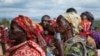 FILE - Women hold their identity cards as they queue to cast their votes in the presidential election, in Giheta, Gitega province, Burundi Wednesday, May 20, 2020. (AP Photo/Berthier Mugiraneza)