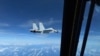 Pesawat tempur J-11 milik Angkatan Laut China terbang mendekati pesawat RC-135 milik militer AS di atas wilayah Laut China Selatan dalam potongan gambar yang diambil dari video pada 21 Desember 2022. (Foto: U.S. Indo-Pacific Command/Handout via Reuters)