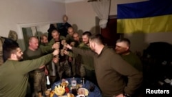 Ukrainian soldiers share a toast to celebrate New Years Eve, in a military rest house, as Russia's attack on Ukraine continues, in region of Donetsk, Ukraine, Dec. 31, 2022. 