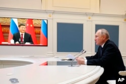 Russian President Vladimir Putin speaks with Chinese President Xi Jinping via a video conference at the Kremlin in Moscow, Russia.