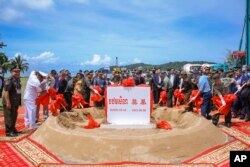 រូប​ឯកសារ៖ ឯកអគ្គរដ្ឋទូត​ចិន​ប្រចាំ​នៅ​កម្ពុជា លោក Wang Wentian និងរដ្ឋមន្ត្រី​ក្រសួង​ការពារ​ជាតិ លោក ទៀ បាញ់ អញ្ជើញ​ចូលរួម​ជា​គណៈអធិបតី​ក្នុងពិធីបញ្ចុះបឋមសិលា និងបើកការដា្ឋនសាងសង់រោងជាងជួសជុលនាវា និងផែសំចត ​នៅ​មូលដ្ឋាន​កងទ័ព​ជើងទឹក​រាម ក្នុង​ខេត្ត​ព្រះសីហនុ ថ្ងៃទី ៨ ខែមិថុនា ឆ្នាំ២០២២។ (Cambodia's Fresh News via AP)