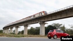 FILE - A car passes under a bridge as a train moves along the Standard Gauge Railway line constructed by China Road and Bridge Corporation and financed by the Chinese government in Athi River, Kenya, June 3, 2022. 