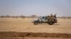 Des soldats burkinabé patrouillent sur la route de Dori au camp de réfugiés de Goudebo.