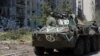 A service member of pro-Russian troops rides on top of an armored personnel carrier amid Russia's invasion of Ukraine, in the town of Popasna in Ukraine's Luhansk region, June 2, 2022. 