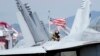 Tentara AS memeriksa jet tempur F/A-18 Super Hornet di dek kapal induk bertenaga nuklir USS Ronald Reagan di Busan, Korea Selatan, 23 September 2022. (Foto: AP)