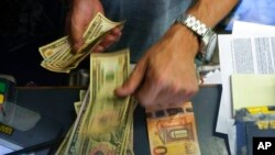 FILE - A cashier changes a 50 euro banknote for U.S. dollars in Rome, July 13, 2022. Rising energy prices have fueled inflation in Italy and other European countries. Annual inflation in the eurozone’s 19 countries rose to 9.1% in August, up from 8.9% in July, the EU statistics agency said.