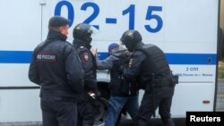 FILE - Russian law enforcement officers detain a person during a rally, after opposition activists called for street protests against the mobilization of reservists ordered by President Vladimir Putin, in Moscow, Sept. 24, 2022.