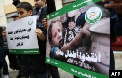 FILE - Children and Lebanese activists from the Islamic group Jamaa Islamiya hold a sit-in in solidarity with the Syrian besieged town of Madaya, outside the International Committee of the Red Cross (ICRC) headquarters in the Lebanese capital Beirut, Jan. 8, 201