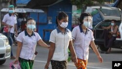 កម្មករ​រោងចក្រ​នាំ​គ្នា​ពាក់​របាំង​មុខ​ការពារ​ពី​ជំងឺ​កូវីដ១៩ ខណៈ​ដែល​ពួកគេ​ដើរ​ឆ្លង​ថ្នល់​ទៅ​ធ្វើការ​​ ទីក្រុង Yangon ប្រទេស​មីយ៉ាន់ម៉ា ថ្ងៃទី១២ ខែតុលា ឆ្នាំ២០២០។ 