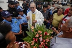 Father Edwin Roman attempts to convince the police to allow relatives of imprisoned and dead anti-government demonstrators to enter the San Miguel Arcangel Church in Masaya, Nicaragua, Nov. 14, 2019.