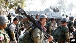 Cambodian soldiers carry their weapons near Preah Vihear temple along the border with Thailand, February 6, 2011.