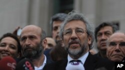 FILE - Can Dundar, the editor-in-chief of opposition newspaper Cumhuriyet, right, and Erdem Gul, left, the paper's Ankara representative, speak to the media after their trial in Istanbul, Friday, March 25, 2016.