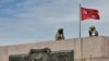 Dua anggota pasukan Rusia tampak berjaga di area yang telah dipasang bendera Uni Soviet yang telah dimodifikasi di Kherson, Ukraina, pada 20 Mei 2022. (Foto: AFP/Olga Maltseva)