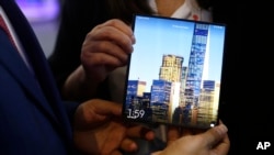 Seorang pria memegang ponsel pintar lipat berteknologi 5G dari Huawei, Mate X, dalam pameran ponsel di Barcelona, Spanyol, 26 Februari 2019.
