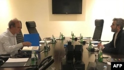 FILE - This handout from Iranian news agency IRNA shows Iranian chief nuclear negotiator Ali Bagheri Kani, right, meeting with European Union nuclear talks coordinator Enrique Mora in Doha, Qatar, June 28, 2022.