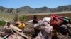 Anak-anak Afghanistan duduk di antara barang-barang mereka yang diselamatkan setelah gempa bumi di desa Gayan, di provinsi Paktika, Afghanistan, Jumat 24 Juni 2022. (Foto: AP)